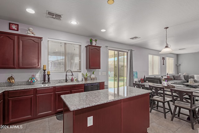 kitchen with a center island, decorative light fixtures, plenty of natural light, and sink