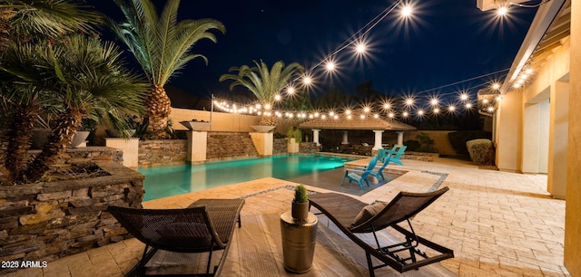 pool at night with a gazebo and a patio