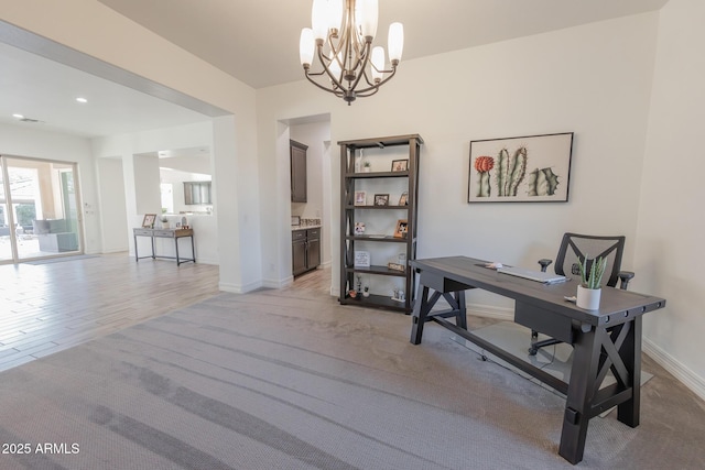 home office featuring an inviting chandelier and light hardwood / wood-style floors