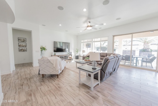 living room with ceiling fan and light wood-type flooring