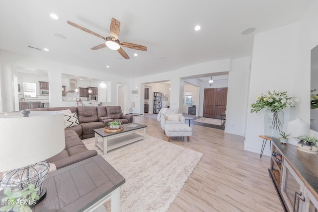 living room featuring ceiling fan and light wood-type flooring