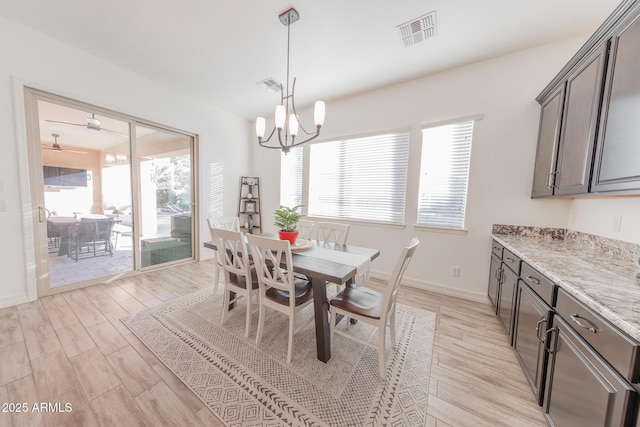 dining area featuring ceiling fan with notable chandelier and light hardwood / wood-style floors