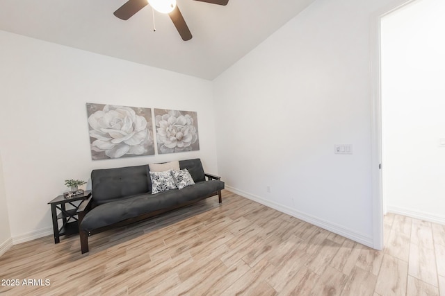 living area featuring ceiling fan, light wood-type flooring, and vaulted ceiling