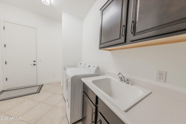 washroom featuring sink, washing machine and dryer, light tile patterned floors, and cabinets