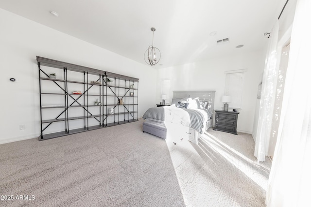 carpeted bedroom with an inviting chandelier