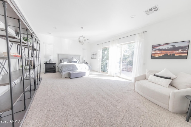 bedroom with access to outside, an inviting chandelier, and carpet