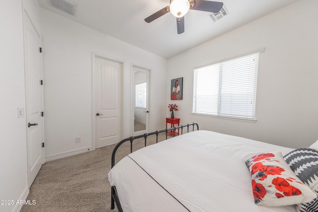 carpeted bedroom with multiple windows and ceiling fan