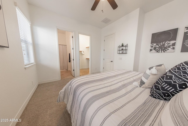 carpeted bedroom featuring ceiling fan and ensuite bath