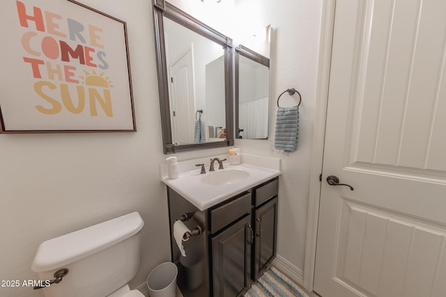 bathroom featuring toilet and vanity