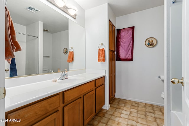 bathroom featuring vanity, toilet, and walk in shower