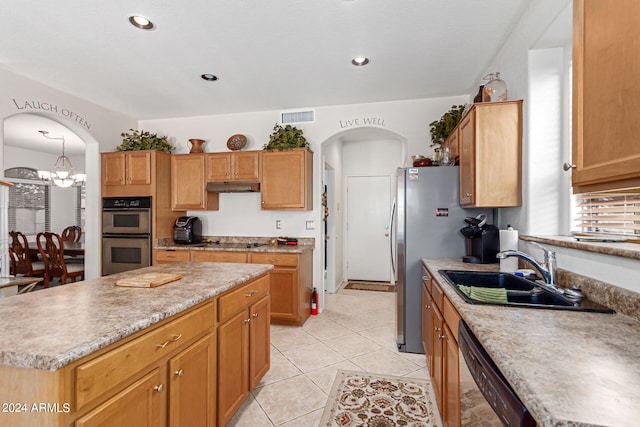 kitchen with a kitchen island, stainless steel appliances, sink, light tile patterned flooring, and a chandelier