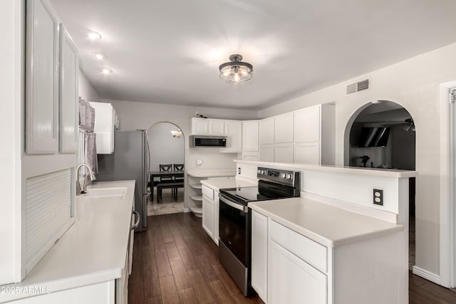 4419 W Vogel Ave, Glendale, AZ 85302 - kitchen featuring appliances with stainless steel finishes, white cabinetry, light countertops, dark wood-style floors, and arched walkways