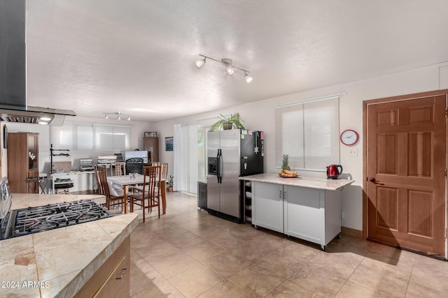 kitchen featuring rail lighting, white cabinetry, stainless steel appliances, and a textured ceiling