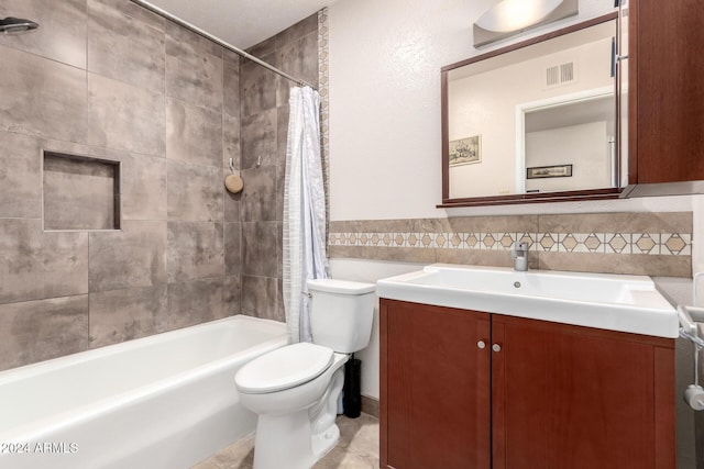 full bathroom featuring shower / tub combo, tile patterned floors, toilet, vanity, and tile walls