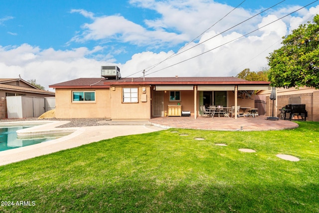 rear view of property with a patio, central AC, and a lawn