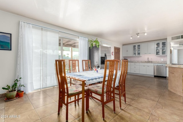 dining space with light tile patterned floors and sink