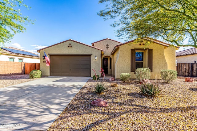 view of front of home with an attached garage, concrete driveway, stucco siding, and fence