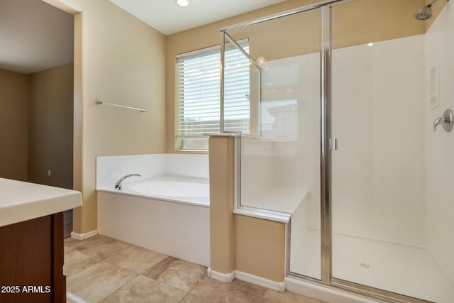 full bath with vanity, baseboards, a bath, and a stall shower