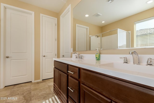 full bathroom featuring double vanity, visible vents, a sink, and a stall shower