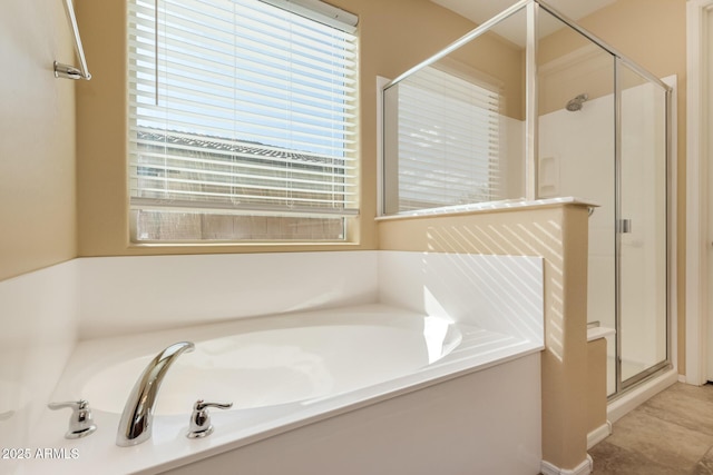 bathroom with a bath, a healthy amount of sunlight, and a shower stall