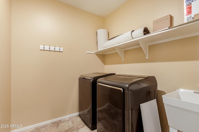 laundry room featuring a sink, baseboards, laundry area, and washing machine and dryer