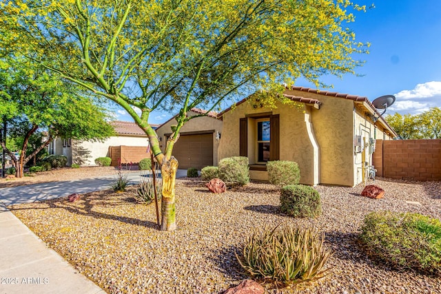 view of front of home featuring fence, an attached garage, stucco siding, a tiled roof, and driveway