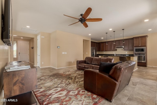living area with recessed lighting, baseboards, and ceiling fan