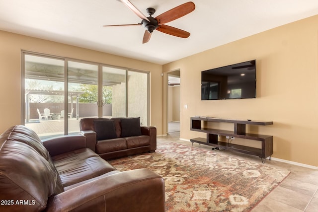 living area featuring baseboards, ceiling fan, and tile patterned floors