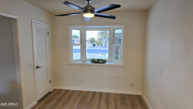 unfurnished bedroom featuring ceiling fan, a textured ceiling, wood-type flooring, and a closet