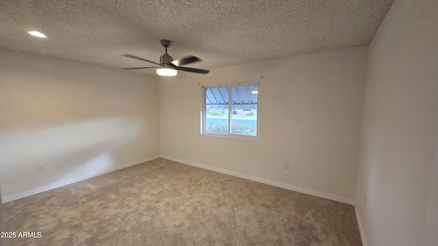 empty room with ceiling fan, a textured ceiling, and carpet floors