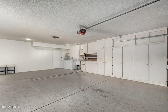 garage with a garage door opener and washing machine and dryer