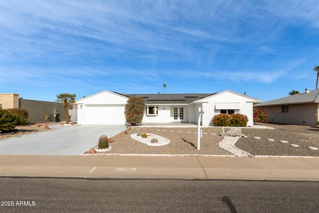 single story home featuring a garage and solar panels