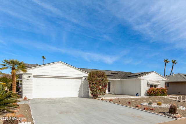 single story home with solar panels and a garage