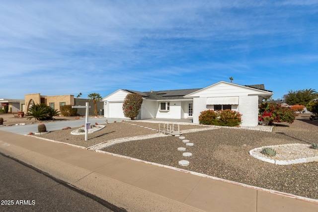 view of front of home with a garage and solar panels