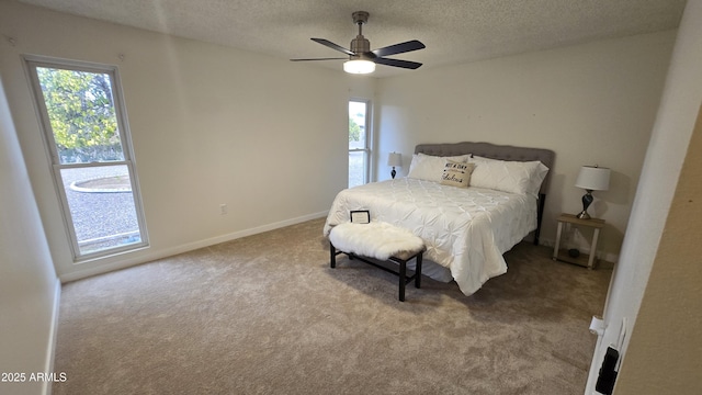 bedroom featuring carpet, multiple windows, a textured ceiling, and ceiling fan