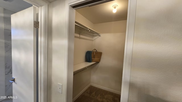 walk in closet featuring dark carpet