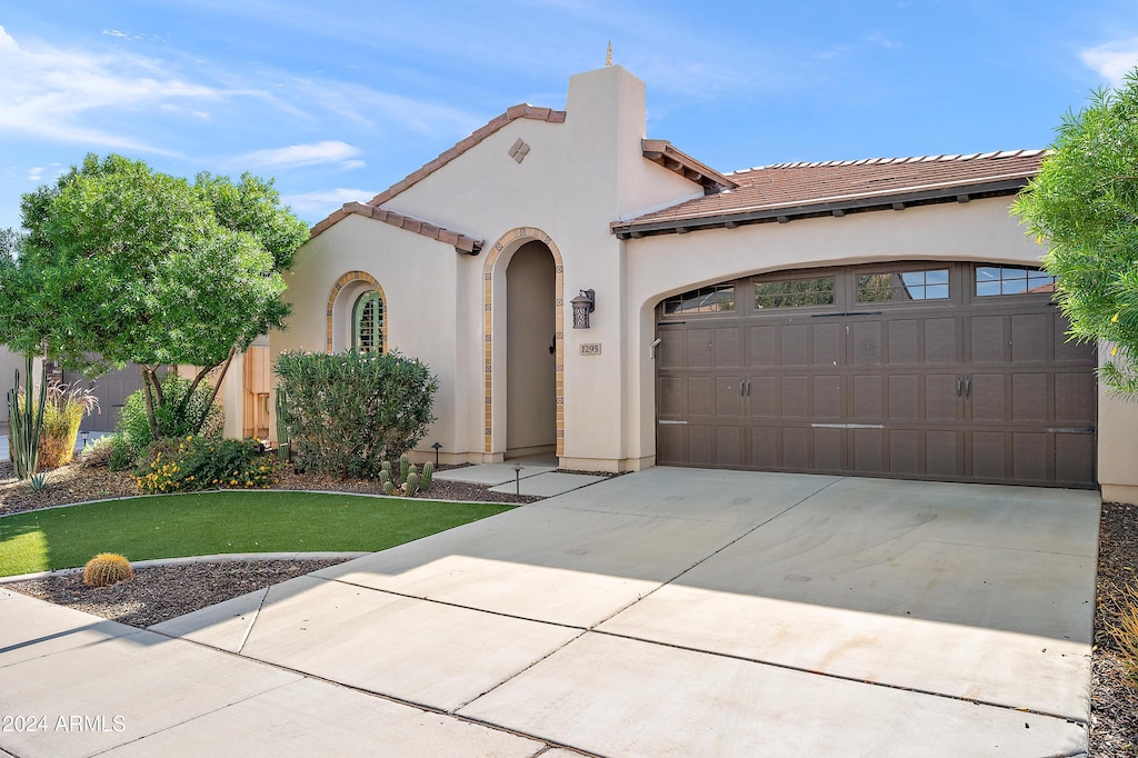 mediterranean / spanish-style house with a garage and a front yard