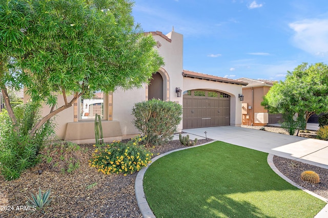 mediterranean / spanish home featuring a front lawn and a garage