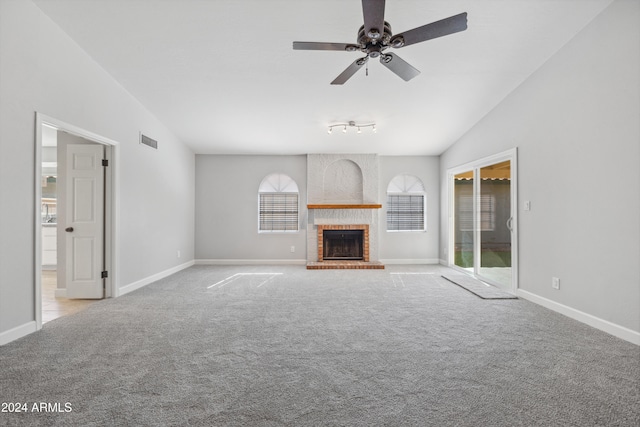 unfurnished living room with light carpet, a fireplace, ceiling fan, and vaulted ceiling