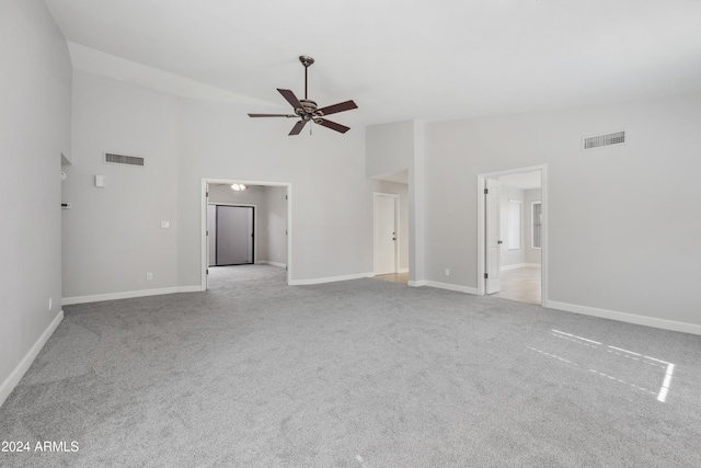 unfurnished living room featuring light carpet, a towering ceiling, and ceiling fan