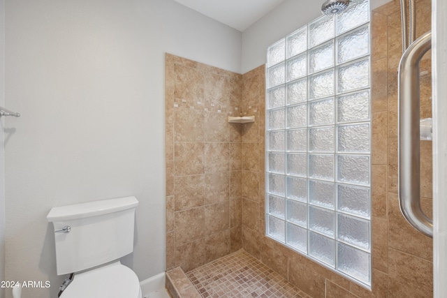 bathroom featuring a tile shower and toilet