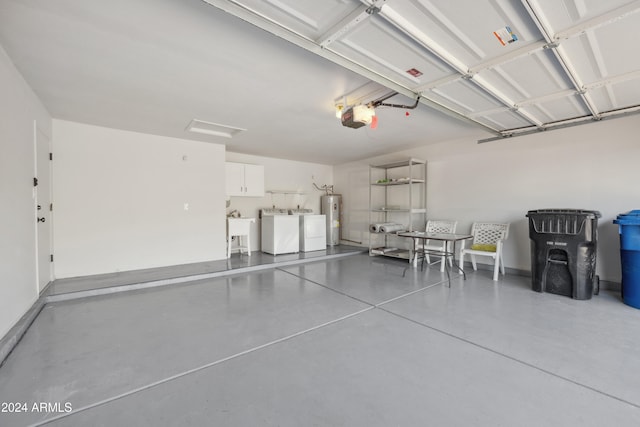 garage with separate washer and dryer, water heater, a garage door opener, and sink