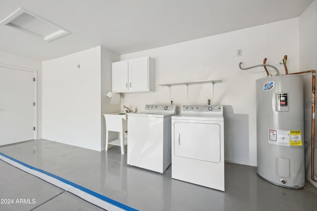 laundry area with water heater, washer and clothes dryer, and cabinets