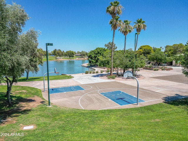 view of basketball court featuring a water view and a yard