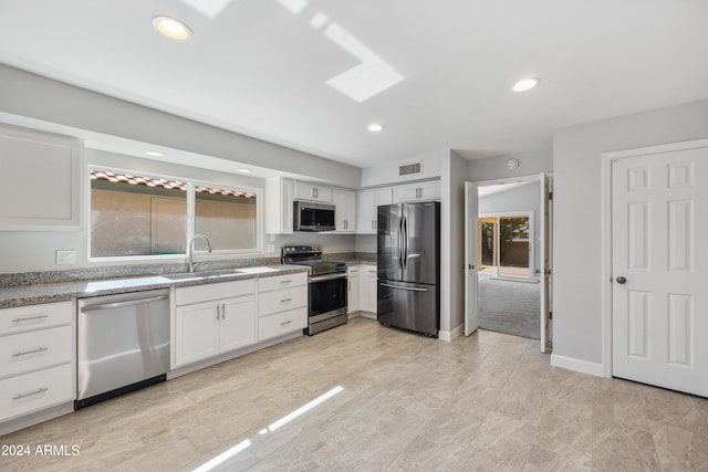 kitchen featuring white cabinetry, sink, stainless steel appliances, and light stone counters