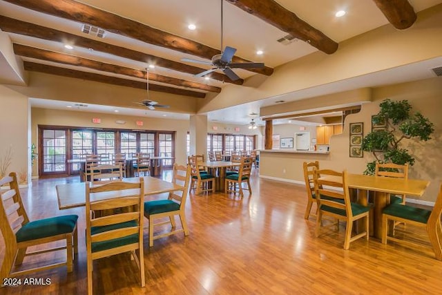 dining area featuring beam ceiling, a wealth of natural light, ceiling fan, and light wood-type flooring