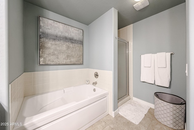 bathroom with tile patterned floors, a stall shower, baseboards, and a garden tub