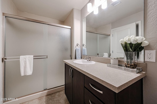 full bath featuring vanity, a shower stall, visible vents, and tile patterned floors