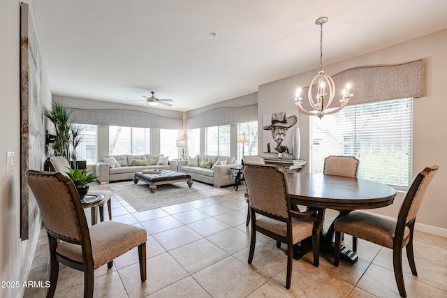 dining area featuring light tile patterned floors, ceiling fan with notable chandelier, baseboards, and a healthy amount of sunlight
