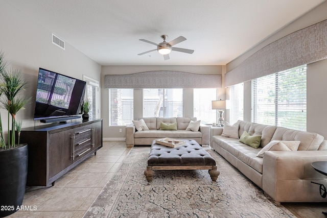 living room with light tile patterned flooring, visible vents, baseboards, and ceiling fan